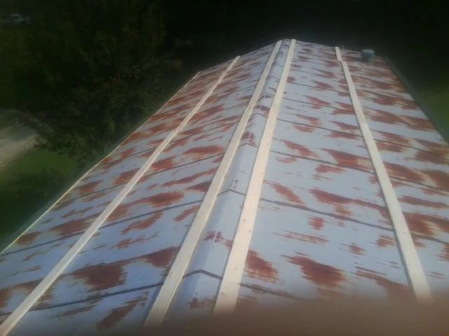 Rusted metal roof panels with new wood purlins before replacement — Storm Damage Roof Repair in Capron by Roofing Brothers