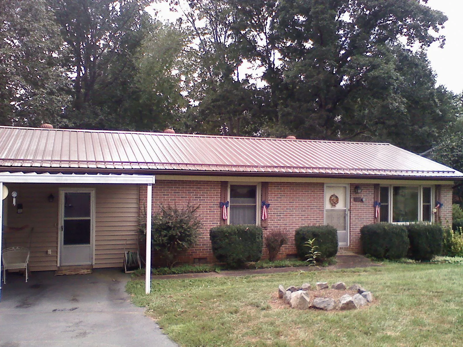 Bronze metal roof and carport on a brick ranch home — Roof Repair work by our crew in Capron